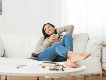 woman sitting on couch drinking coffee